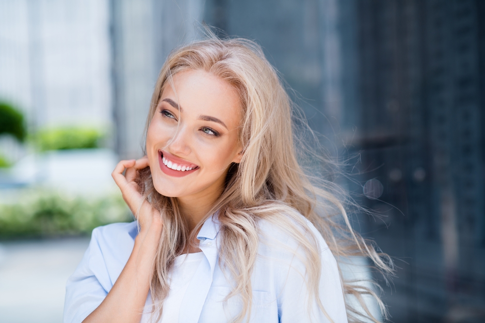 Confident Smile After Dental Care – Lake Forest Dentist Smiling woman outdoors with bright, healthy teeth after a dental visit – Lake Forest Dentist
